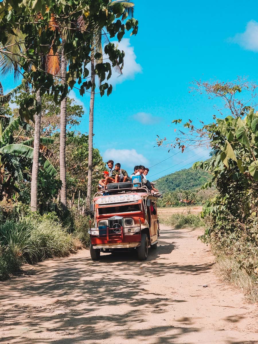 Car with Filipino kids on the roof driving from Nacpan beach