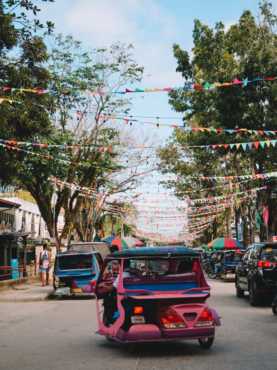 Tricycles in El Nido town with flags in the background