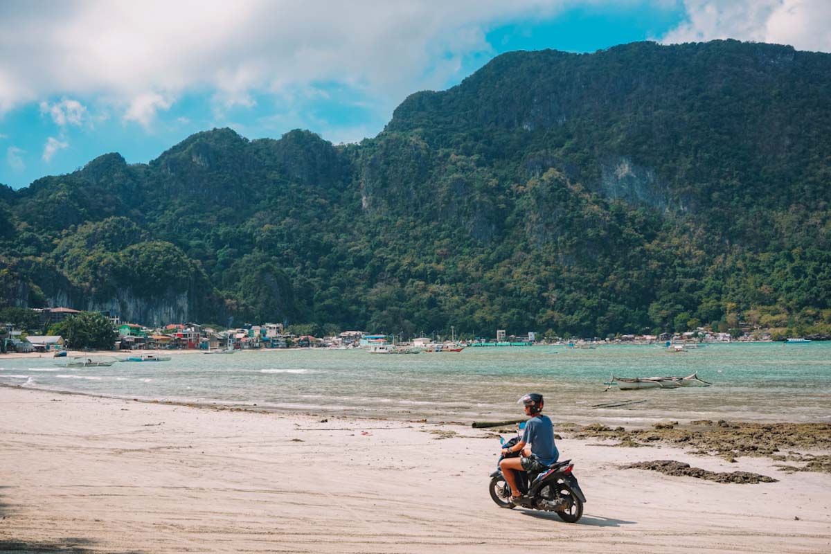 Driving a motorbike on El Nido beach near El Nido town